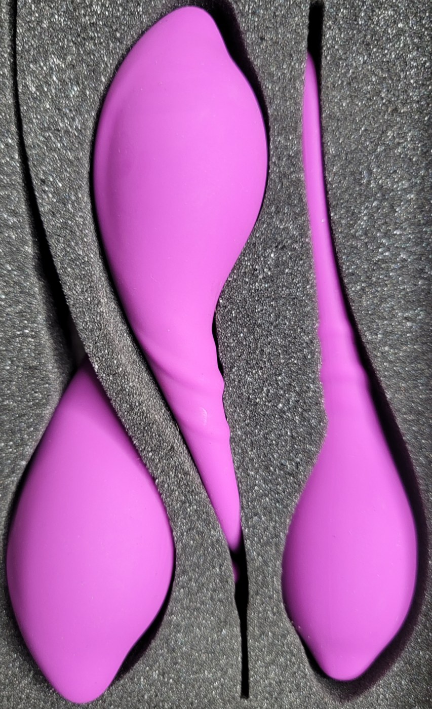 Actual three purple pelvic floor exercise weights in their foam case
